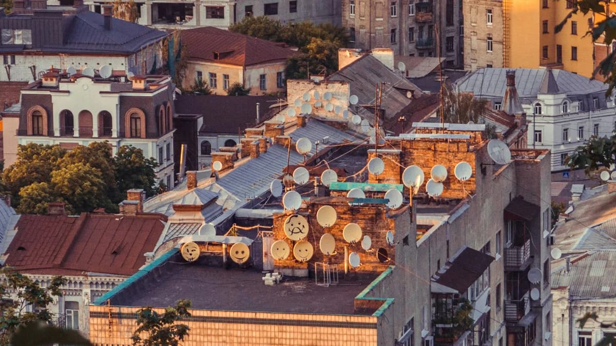 Luftaufnahme einer Stadt in der Abenddämmerung mit vielen beleuchteten Fenstern