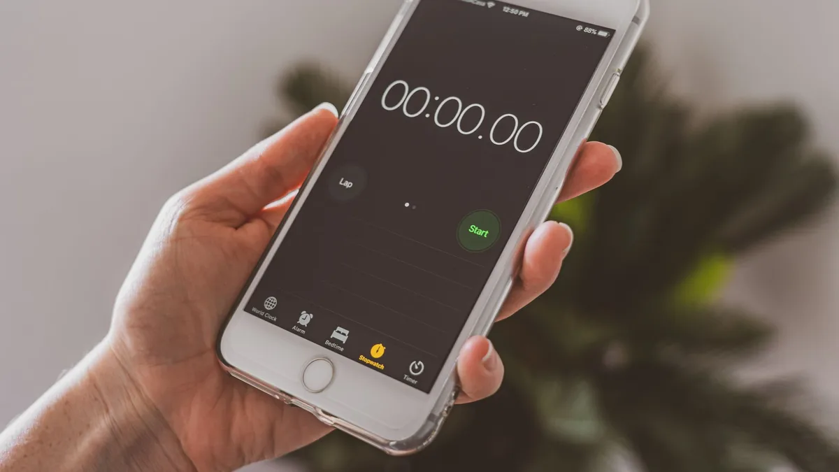Hand hält ein Smartphone mit einer Stoppuhr-Anzeige bei 00:00:00