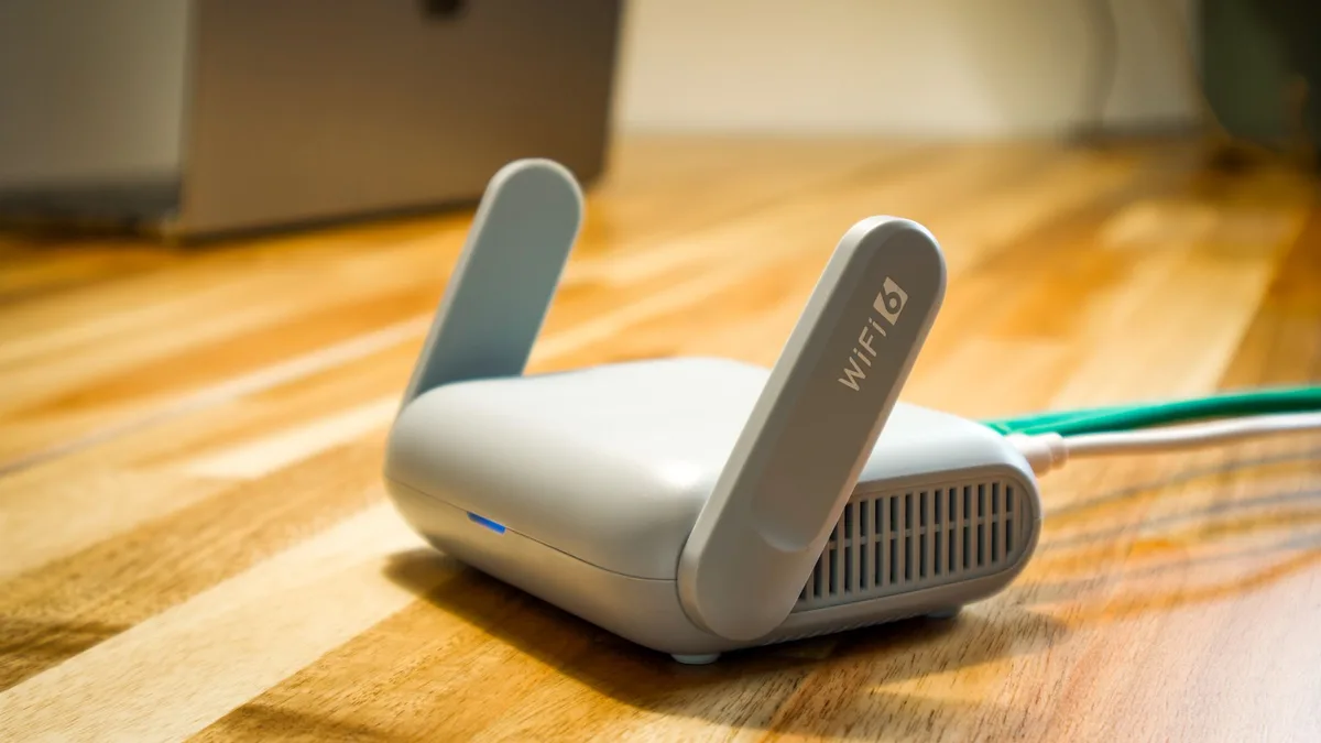 WLAN-Router mit Antennen steht auf einem Holztisch am Fenster